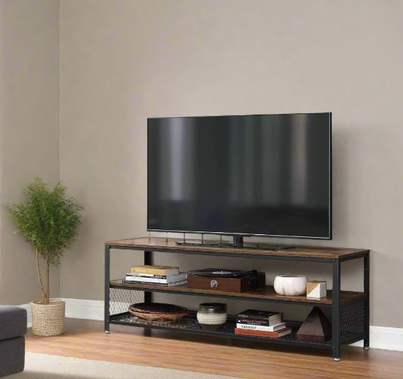 TV on a wooden stand against a beige wall with a plant to the left.