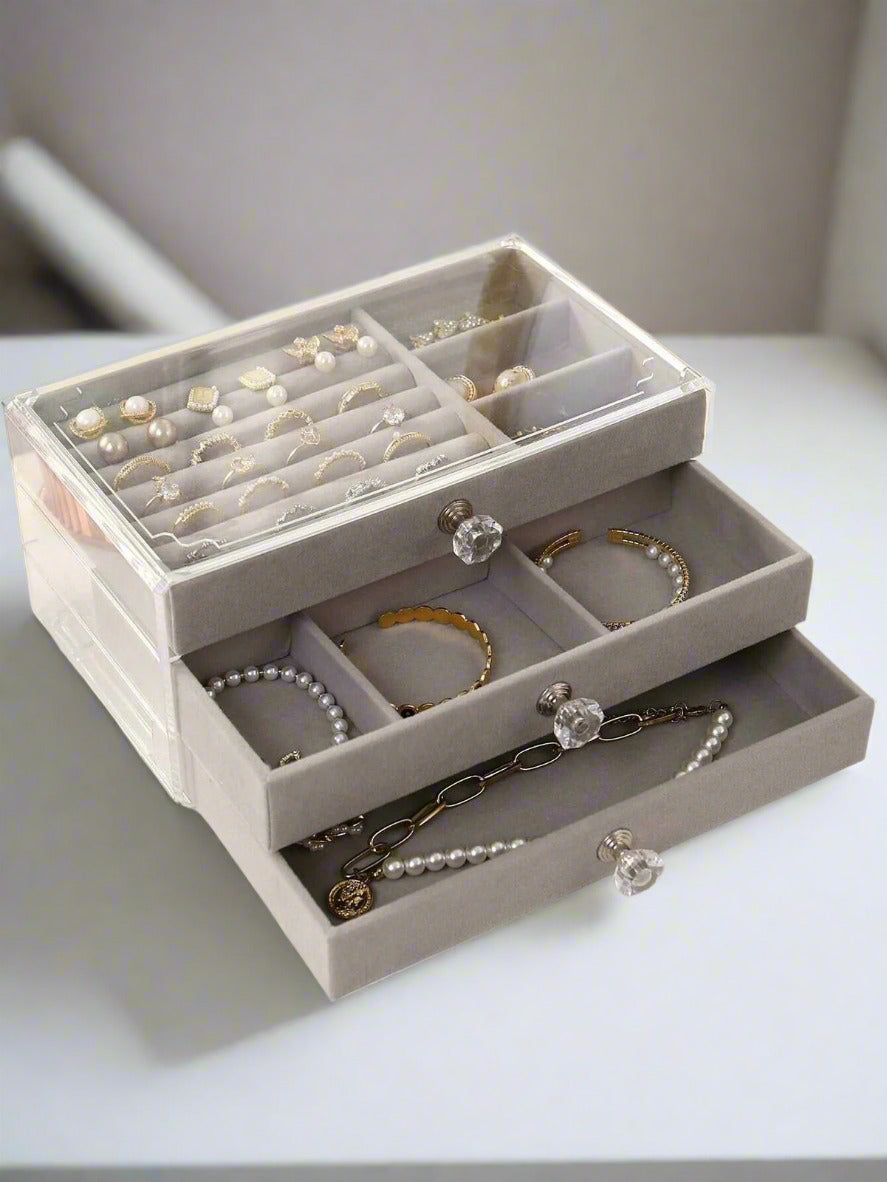 Gray jewelry organizer with jewelry on a white surface