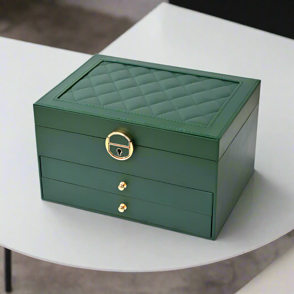 Green jewelry box with gold accents on a white surface