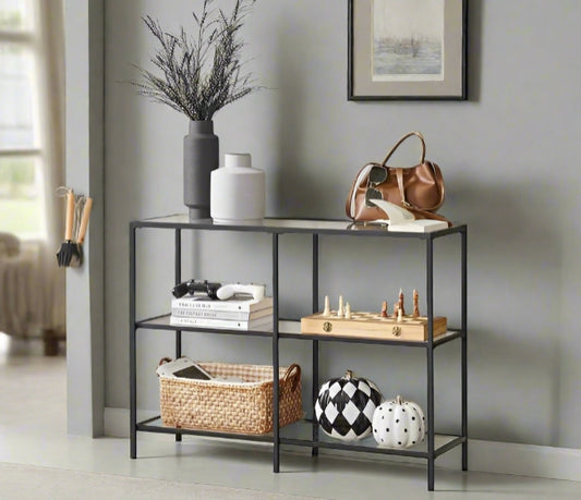 Modern 3-tier black steel console table with clear tempered glass shelves in stylish living room

