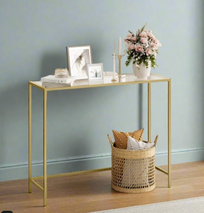 Modern console table with golden metal frame and tempered glass top in living room setting

